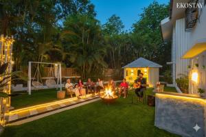 um grupo de pessoas sentadas em torno de um incêndio em um quintal em Ekostay Luxe - CASA SIA - Ideal for Big Groups- Poker Table em Lonavala