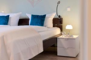 een slaapkamer met een bed en een nachtkastje met een lamp bij Bernsteinquartier BQ 6e in Kolpinsee