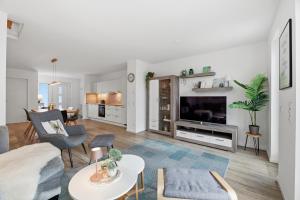 een woonkamer met een bank en een tv bij Bernsteinquartier BQ 6e in Kolpinsee