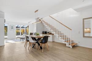 een keuken en eetkamer met een tafel en een trap bij Bernsteinquartier BQ 6e in Kolpinsee