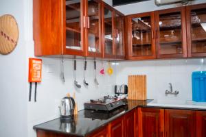 eine Küche mit Holzschränken und einer Arbeitsplatte in der Unterkunft The Hub Train House Apartments in Zanzibar City + 63 Fotos