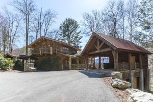 een groot houten huis met een oprit ervoor bij Red Stag Lodge at Eagles Nest in Banner Elk