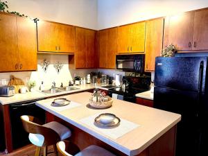 a kitchen with wooden cabinets and a black refrigerator at Loft on Lake Ave in Duluth
