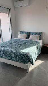 a bed with a green comforter in a bedroom at Villa Outaouais T4 in Bielle