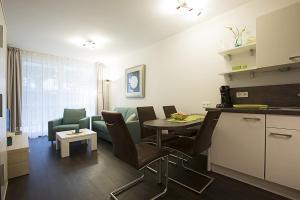 a kitchen and living room with a table and chairs at Residenz am Balmer See - BS 05 mit Wellnessbereich in Balm