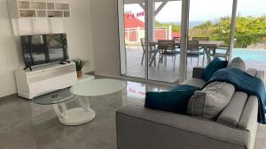 a living room with a couch and a table at Villa Outaouais T4 in Bielle
