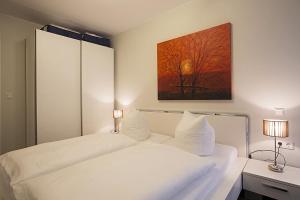 two beds in a bedroom with a painting on the wall at Residenz am Balmer See - BS 05 mit Wellnessbereich in Balm