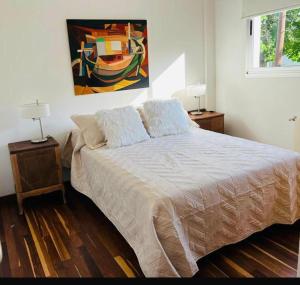 a bedroom with a bed and a painting on the wall at Tempo Apart in La Plata