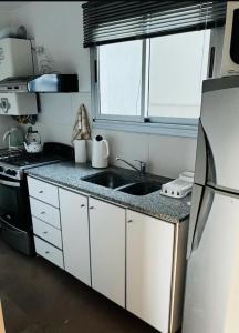 a small kitchen with a sink and a refrigerator at Tempo Apart in La Plata