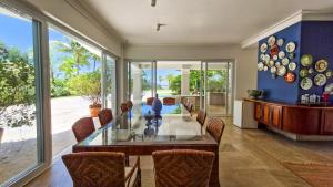 Un comedor con una mesa de cristal y sillas. en Mansão Pé na Areia no Condomínio Cocanha, en Água Boa