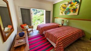 2 camas en una habitación con paredes verdes y ventana en Mansão Pé na Areia no Condomínio Cocanha, en Água Boa 61 fotos más