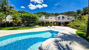 una casa con piscina delante en Mansão Pé na Areia no Condomínio Cocanha, en Água Boa