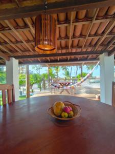 a bowl of fruit on a table with a hammock at Villa Tarifa Icaraizinho in Amontada