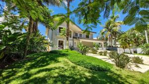 una vista exterior de una casa con palmeras en Mansão Pé na Areia no Condomínio Cocanha, en Água Boa