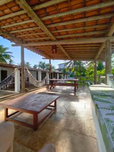 a patio with two picnic tables and a hammock at Villa Tarifa Icaraizinho in Amontada
