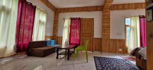 a living room with a table and a couch at woodstock villa & cafe in Jibhi +2 photos