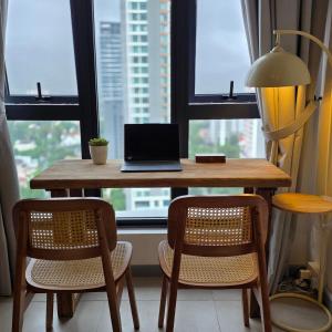 a laptop computer sitting on a wooden table in front of a window at 22Macalisterz Georgetown Studio in George Town