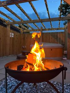 Mill House Farm Pods - Lapwing Lodge في Pilling: حفرة نار في فناء مع النيران