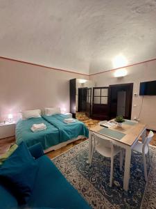 a room with a bed and a table and a couch at Sancti Temporary Home Urbino in Urbino