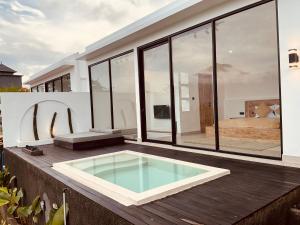 a house with a swimming pool on a deck at Aluna Villa Kintamani - Private villa & Hot spring pool in Kubupenlokan
