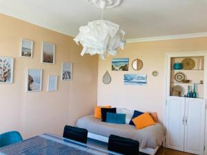 een eetkamer met een tafel en een kroonluchter bij Les Pieds dans l'eau appartement vue mer in Dieppe