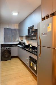 a kitchen with a stainless steel refrigerator and appliances at Ponta Negra Apartment in Manaus +20 photos