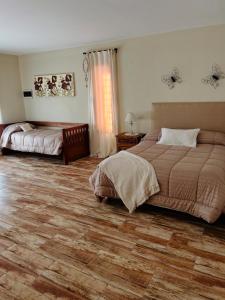 une chambre avec deux lits et un parquet dans l'établissement Corazón de Ayrampos APART, à Villa Dolores