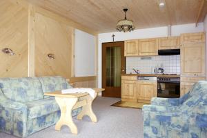a living room with a couch and a table and a kitchen at Ferienhaus Tirolerhof in Kals am Großglockner +27 photos