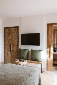 een slaapkamer met een bed en een bank met een televisie bij Ultima in Tías