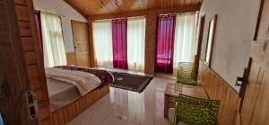 a bedroom with a bed in a room with windows at woodstock villa & cafe in Jibhi