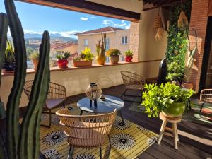 eine Terrasse mit Stühlen und einem Tisch und Topfpflanzen in der Unterkunft Gite cosy dans une demeure de charme - Laura in Thuir