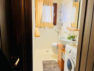 een badkamer met toilet en wastafel en wasmachine bij GuestHost - Petite Fleur - Cozy La Thuile Flat in La Thuile +10 foto's