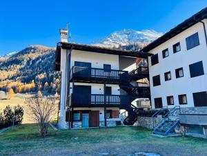 een appartementencomplex met een trap voor een berg bij GuestHost - Petite Fleur - Cozy La Thuile Flat in La Thuile