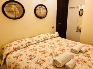 een slaapkamer met een bed met twee handdoeken erop bij GuestHost - Petite Fleur - Cozy La Thuile Flat in La Thuile