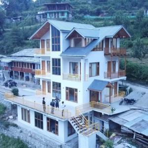an aerial view of a house with people standing on the balcony at woodstock villa & cafe in Jibhi