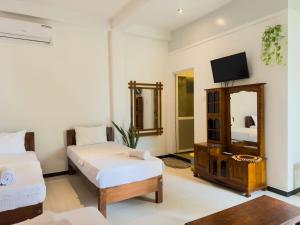una stanza d'albergo con un letto e uno specchio di JAMI River Side Hotel & Yala Safari Place a Tissamaharama