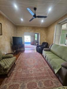 a living room with a couch and a ceiling fan at The Homestead at Koringberg Country Cottages in Koringberg
