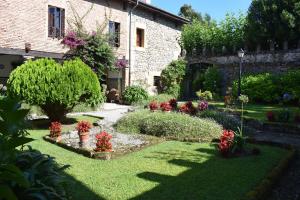 a garden with flowers in front of a building at Casona De Linares in Selaya