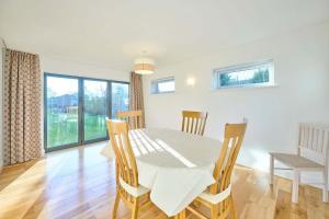 een eetkamer met een witte tafel en stoelen bij Host & Stay - WillowStay in Martham