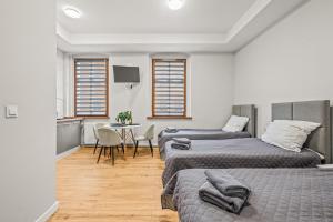 une chambre avec deux lits et une table avec une télévision dans l'établissement Central Platinum Apartments 2, à Rybnik