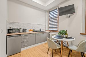 une cuisine avec une table, des chaises et un comptoir dans l'établissement Central Platinum Apartments 2, à Rybnik