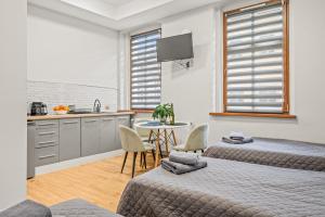 une chambre avec deux lits et une cuisine avec une table dans l'établissement Central Platinum Apartments 2, à Rybnik