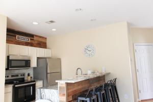 a kitchen with a counter with chairs in it at Royal Jr. Suite in Sunset Beach
