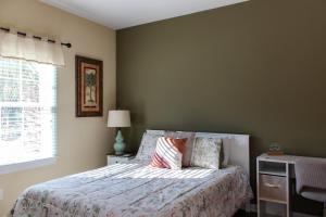 a bedroom with a bed and a window at Royal Jr. Suite in Sunset Beach