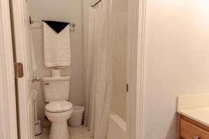 a white bathroom with a toilet and a shower at The Suite at 205 Royal Poste Rd in Sunset Beach