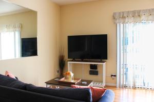 a living room with a couch and a flat screen tv at Royal Jr. Suite in Sunset Beach