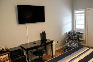 a bedroom with a desk and a television on the wall at The Villa at 125 Royal Poste Rd in Sunset Beach
