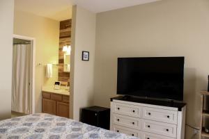 a bedroom with a flat screen tv on a dresser at Royal Villa in Sunset Beach