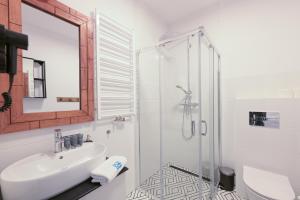 een badkamer met wastafel en douche met spiegel bij Nadmorska Florina Apartamenty dwupoziomowe z tarasami in Łeba +81 foto's