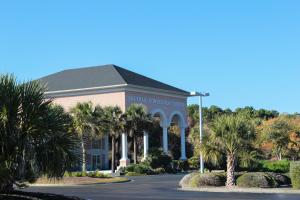 a school building with palm trees and a road at Beach Bungalow by Coastal Concierge in Sunset Beach +7 photos
